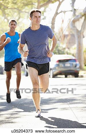 Stock Image - Male Runners Exercising On Suburban Street. Fotosearch