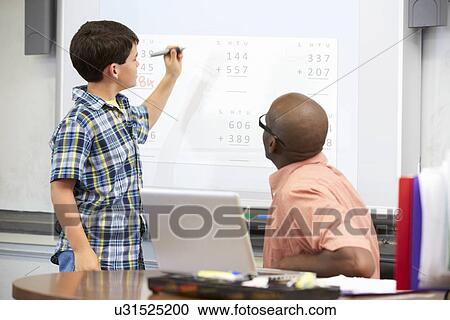 Stock Image - Male Student Writing Answer On Whiteboard. Fotosearch