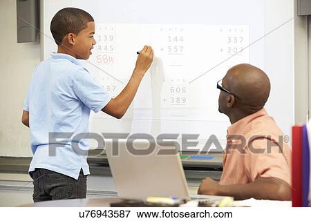 Stock Photo - Male Student Writing Answer On Whiteboard. Fotosearch