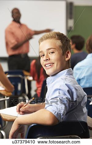 Stock Image - Male Teenage Pupil In Classroom. Fotosearch