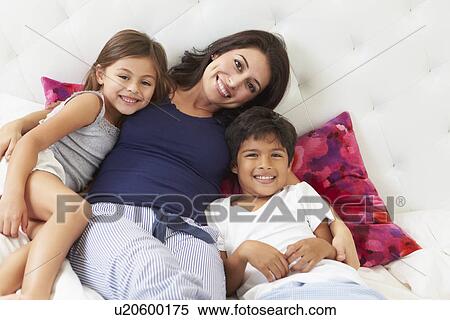 Mother And Children Relaxing In Bed Wearing Pajamas View Large Photo Image Stock Photography - Mother And Children Relaxing In Bed Wearing Pajamas. Fotosearch