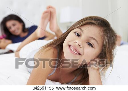 Stock Photography - Mother And Children Relaxing In Bed Wearing Pajamas. Fotosearch