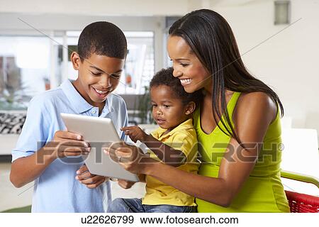 Mother And Children Using Digital Tablet In Kitchen Together View Large Photo Image Stock Photo - Mother And Children Using Digital Tablet In Kitchen Together. Fotosearch
