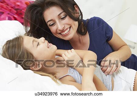 Stock Photograph - Mother And Daughter Lying In Bed Together. Fotosearch