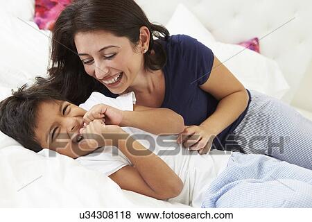 Stock Photo - Mother And Son Lying In Bed Together. Fotosearch