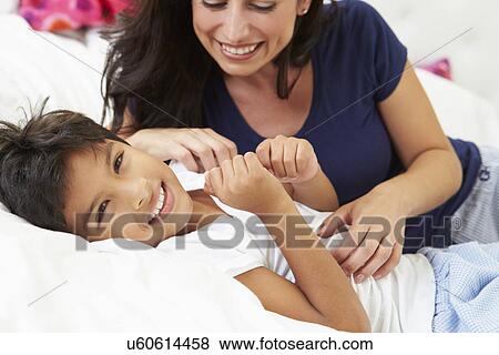 Stock Photo - Mother And Son Lying In Bed Together. Fotosearch