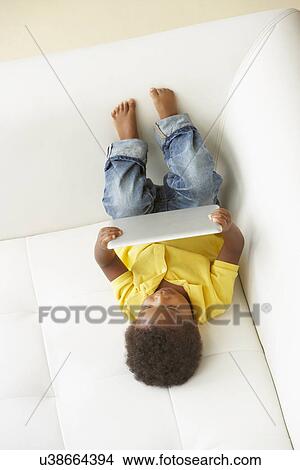 Overhead View Of Boy On Sofa Playing With Digital Tablet View Large Photo Image Picture - Overhead View Of Boy On Sofa Playing With Digital Tablet. Fotosearch