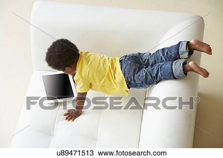 Overhead View Of Boy On Sofa Playing With Digital Tablet View Large Photo Image Stock Image - Overhead View Of Boy On Sofa Playing With Digital Tablet. Fotosearch