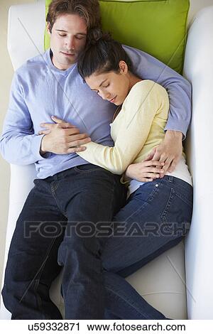 Stock Image - Overhead View Of Couple Relaxing On Sofa. Fotosearch