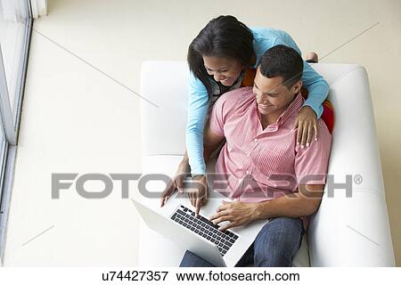 Overhead View Of Couple Relaxing On Sofa Using Laptop View Large Photo Image Stock Photo - Overhead View Of Couple Relaxing On Sofa Using Laptop. Fotosearch