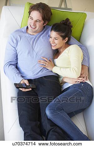 Picture - Overhead View Of Couple Watching TV On Sofa. Fotosearch