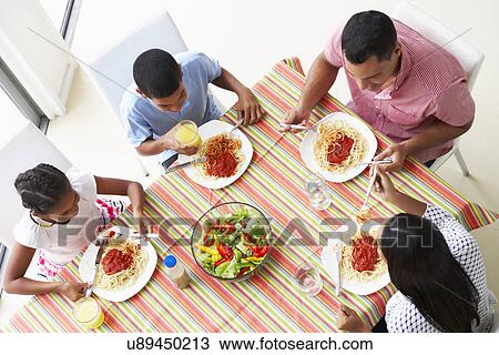 Stock Image - Overhead View Of Family Eating Meal Together. Fotosearch