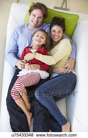 Stock Photo - Overhead View Of Family Relaxing On Sofa. Fotosearch