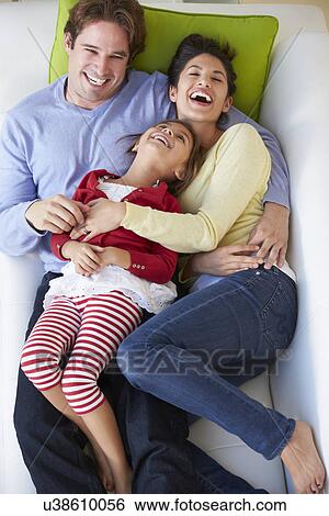 Stock Photograph - Overhead View Of Family Relaxing On Sofa. Fotosearch