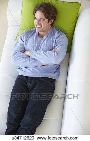 Stock Photo - Overhead View Of Man Relaxing On Sofa. Fotosearch