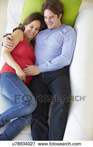 Overhead View Of Man Relaxing On Sofa With Pregnant Wife View Large Photo Image Stock Photo - Overhead View Of Man Relaxing On Sofa With Pregnant Wife . Fotosearch