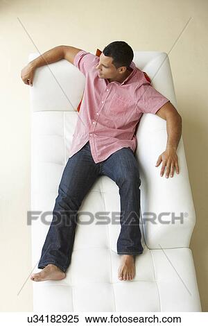 Stock Photography - Overhead View Of Man Relaxing On Sofa. Fotosearch