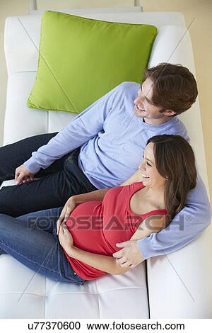 Overhead View Of Man Watching TV On Sofa With Pregnant Wife View Large Photo Image Stock Image - Overhead View Of Man Watching TV On Sofa With Pregnant Wife . Fotosearch