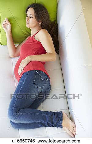 Stock Photograph - Overhead View Of Pregnant Woman Sleeping On Sofa. Fotosearch