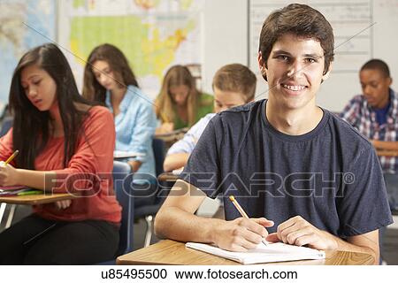 Portrait Of Male Pupil Studying At Desk In Classroom View Large Photo Image Stock Image - Portrait Of Male Pupil Studying At Desk In Classroom. Fotosearch