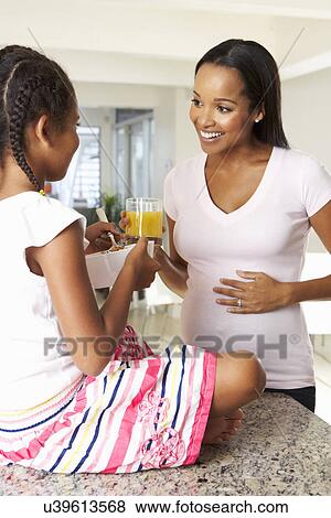 Pregnant Mother And Daughter Drinking Juice In Kitchen View Large Photo Image Stock Photo - Pregnant Mother And Daughter Drinking Juice In Kitchen. Fotosearch
