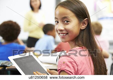 Stock Photo - Pupil In Class Using Digital Tablet. Fotosearch