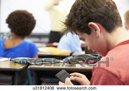 Pupil Sending Text Message On Mobile Phone In Class View Large Photo Image Stock Photo - Pupil Sending Text Message On Mobile Phone In Class. Fotosearch