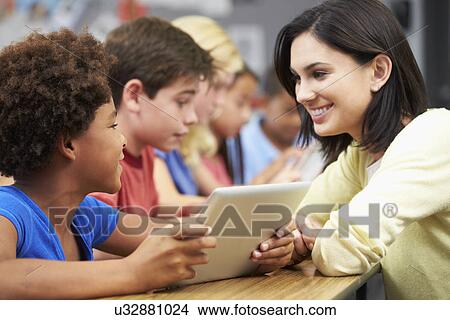 Pupils In Class Using Digital Tablet With Teacher View Large Photo Image Picture - Pupils In Class Using Digital Tablet With Teacher. Fotosearch