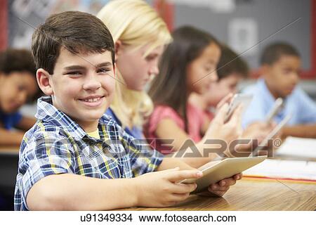 Picture - Pupils In Class Using Digital Tablet. Fotosearch