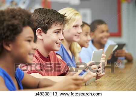 Stock Image - Pupils In Class Using Digital Tablet. Fotosearch