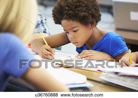 Stock Photo - Pupils Studying At Desks In Classroom. Fotosearch