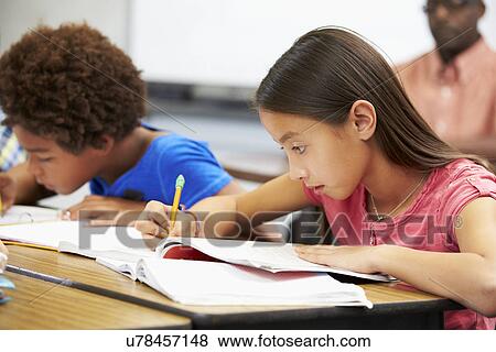 Pupils Studying At Desks In Classroom View Large Photo Image Stock Photo - Pupils Studying At Desks In Classroom. Fotosearch
