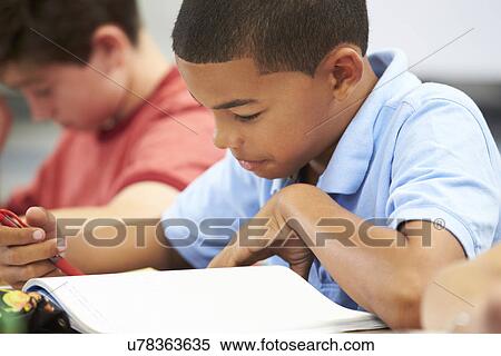 Stock Photography - Pupils Studying At Desks In Classroom. Fotosearch