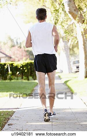 Rear View Of Male Runner Exercising On Suburban Street View Large Photo Image Stock Image - Rear View Of Male Runner Exercising On Suburban Street. Fotosearch