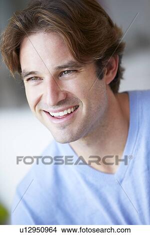 Picture - Smiling Man Sitting On Sofa. Fotosearch