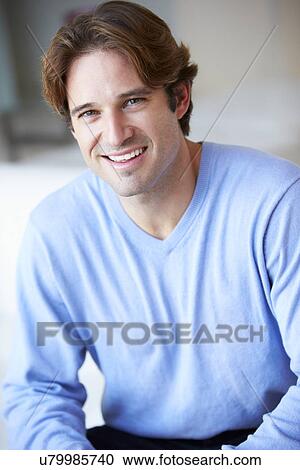 Stock Image - Smiling Man Sitting On Sofa. Fotosearch