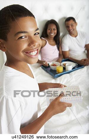 Stock Photograph - Son Bringing Parents Breakfast In Bed. Fotosearch