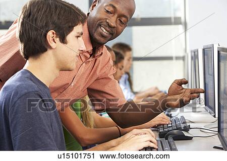 Teacher Helping Students Working At Computers In Classroom View Large Photo Image Stock Image - Teacher Helping Students Working At Computers In Classroom. Fotosearch