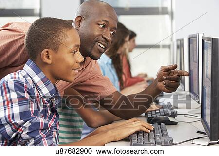 Teacher Helping Students Working At Computers In Classroom View Large Photo Image Stock Image - Teacher Helping Students Working At Computers In Classroom. Fotosearch
