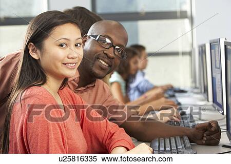 Teacher Helping Students Working At Computers In Classroom View Large Photo Image Stock Photography - Teacher Helping Students Working At Computers In Classroom. Fotosearch