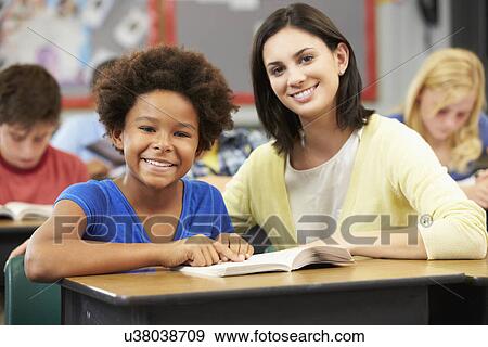 Teacher Reading With Female Pupil In Class View Large Photo Image Stock Photo - Teacher Reading With Female Pupil In Class. Fotosearch