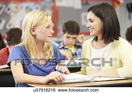 Stock Photograph - Teacher Reading With Female Pupil In Class. Fotosearch
