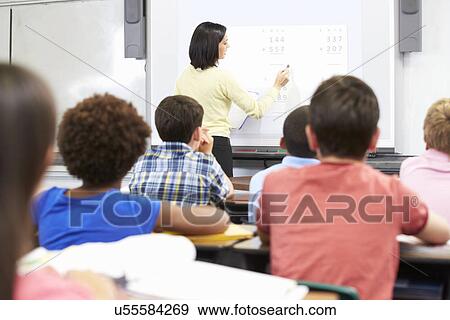 Stock Photo - Teacher Standing In Class Using Interactive Whiteboard. Fotosearch