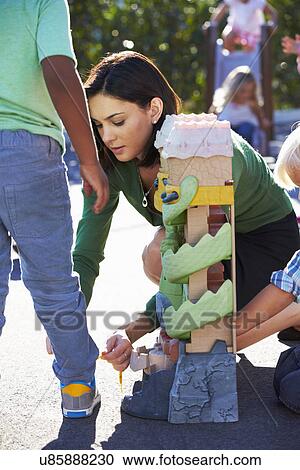 Teacher Tying Male Pupils Shoelace in Playground View Large Photo Image Stock Image - Teacher Tying Male Pupils Shoelace in Playground. Fotosearch
