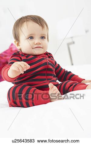 Toddler Sitting On Bed Wearing Pajamas View Large Photo Image Stock Image - Toddler Sitting On Bed Wearing Pajamas. Fotosearch
