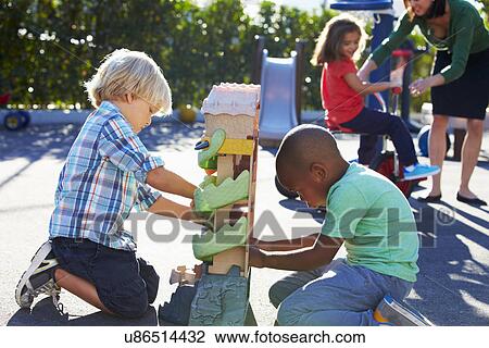 Two Boys Playing With Toy In Playground View Large Photo Image Stock Image - Two Boys Playing With Toy In Playground. Fotosearch