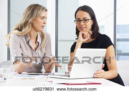 Stock Image - Two Businesswomen Meeting In Office. Fotosearch
