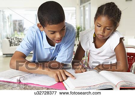 Stock Photo - Two Children Doing Homework Together In Kitchen. Fotosearch
