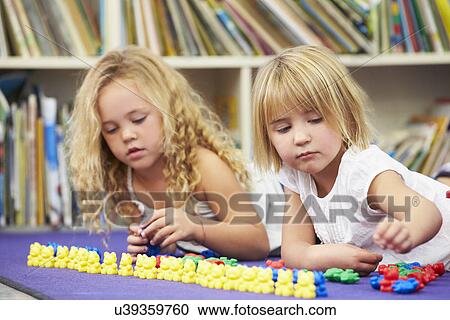 Stock Image - Two Elementary Pupils Counting Together In Classroom. Fotosearch