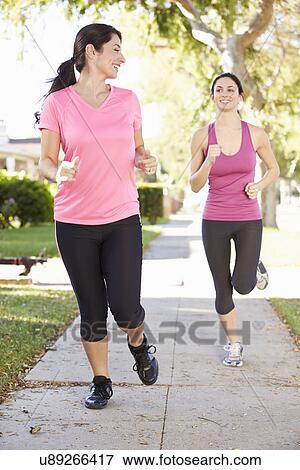 Two Female Runners Exercising On Suburban Street View Large Photo Image Stock Photo - Two Female Runners Exercising On Suburban Street. Fotosearch
